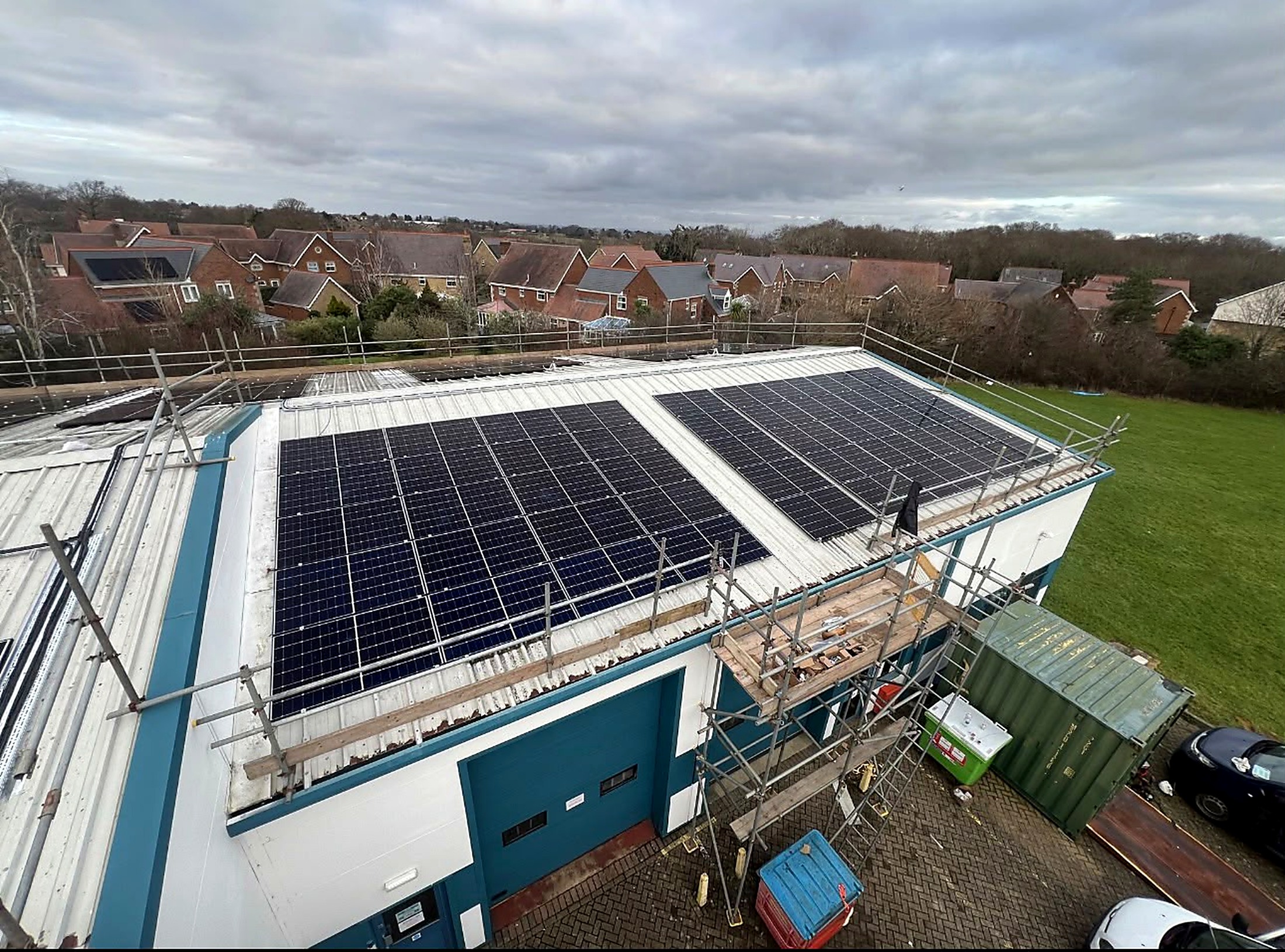 Aerial view of large commercial solar PV array installed across multiple roof aspects on a building in the Isle of Wight